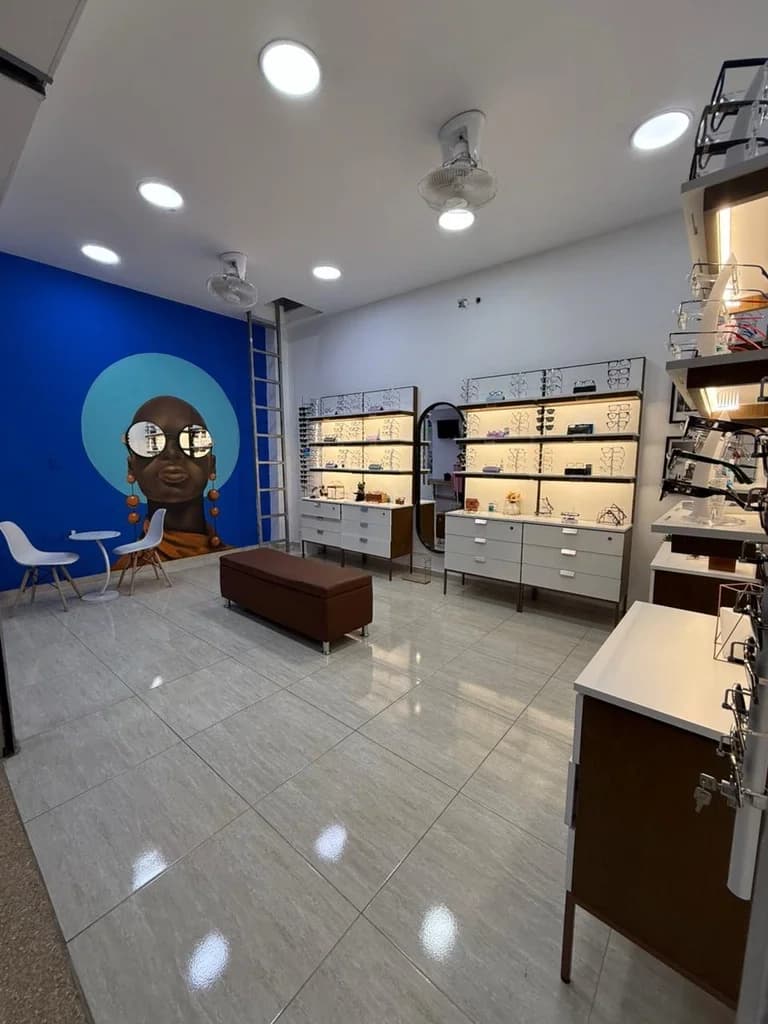 Vista interior de la sala de ventas de Optilux Valledupar, mostrando pasillos amplios y organización de productos.