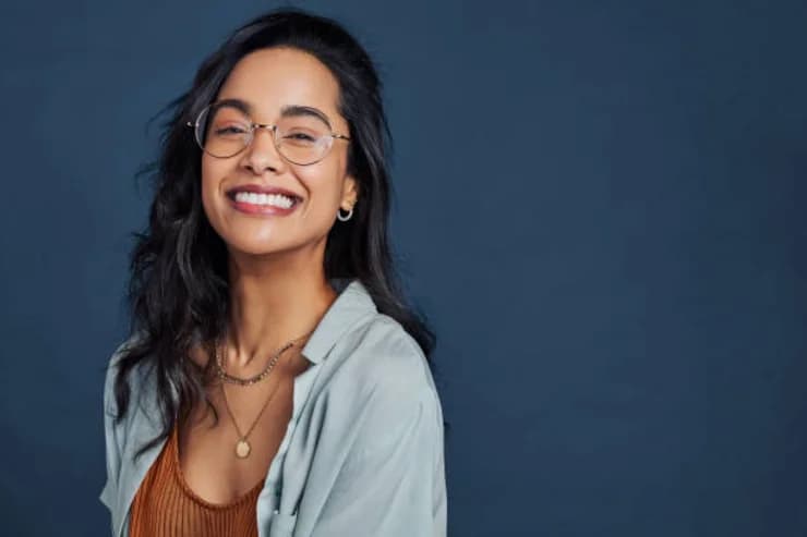 Monturas de gafas graduadas modernas para mujer. Mujer sonriendo con lentes de marco metálico redondo.